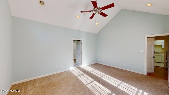 unfurnished bedroom with carpet flooring, a spacious closet, high vaulted ceiling, and ceiling fan