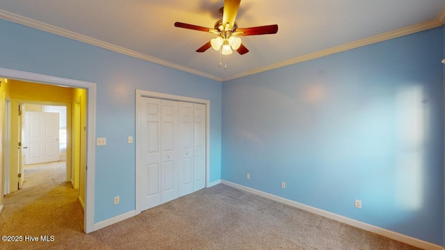 unfurnished bedroom with a closet, light colored carpet, ceiling fan, and crown molding