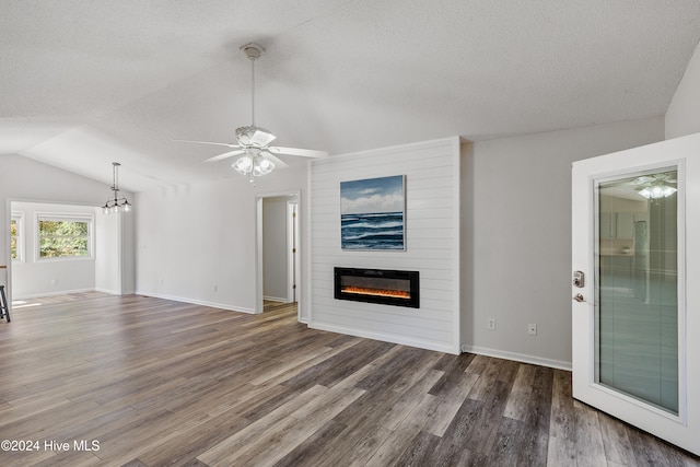 unfurnished living room with a textured ceiling, lofted ceiling, a fireplace, and dark hardwood / wood-style floors