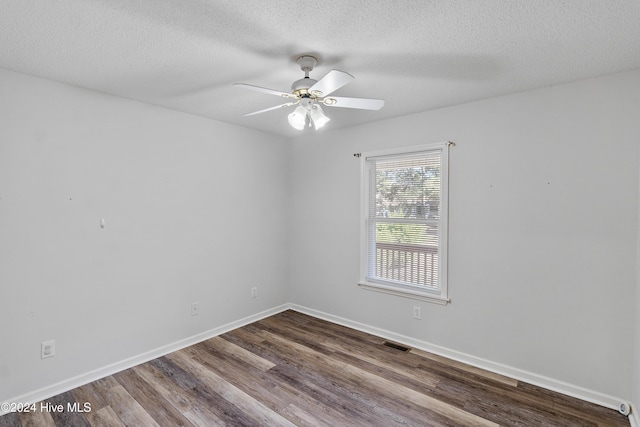 unfurnished room with dark wood-type flooring, a textured ceiling, ceiling fan, and visible vents