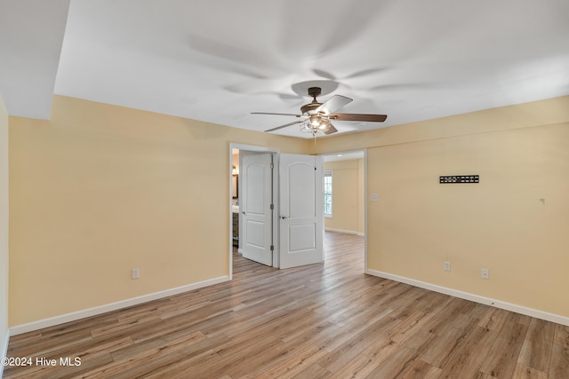 empty room with light wood-style floors, baseboards, and a ceiling fan