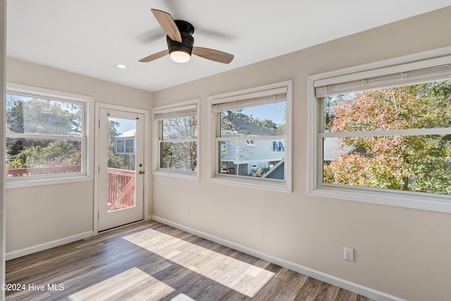 unfurnished sunroom featuring ceiling fan and a wealth of natural light