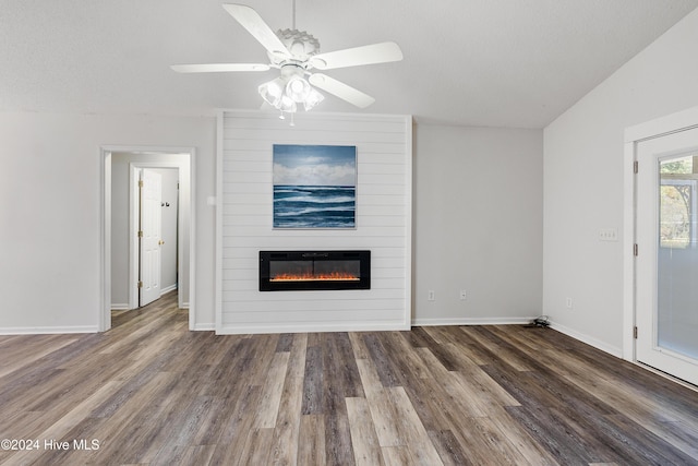 unfurnished living room featuring baseboards, a large fireplace, a ceiling fan, and wood finished floors