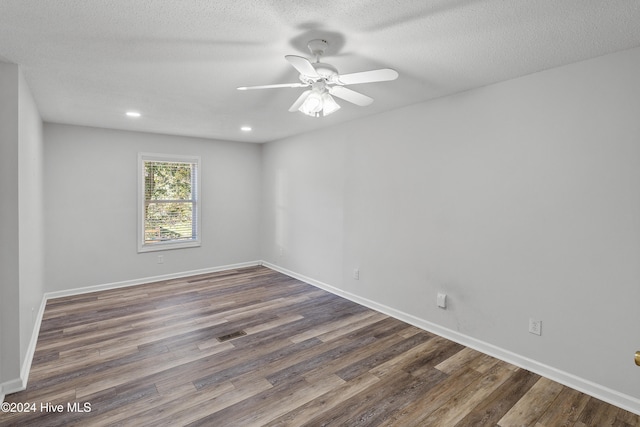 empty room featuring dark hardwood / wood-style floors, ceiling fan, and a textured ceiling