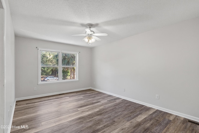 spare room with visible vents, baseboards, ceiling fan, a textured ceiling, and wood finished floors