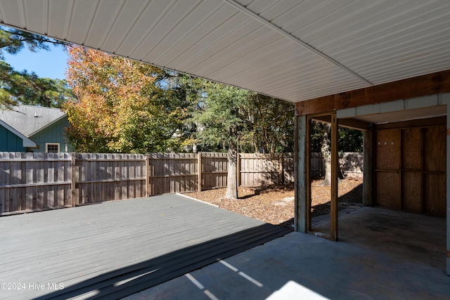wooden terrace with a patio and a fenced backyard