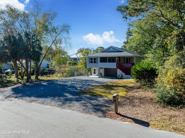 view of front of home featuring fence and gravel driveway