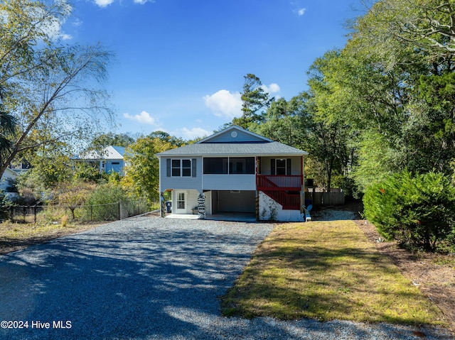 view of front of house featuring a front yard, fence, and gravel driveway