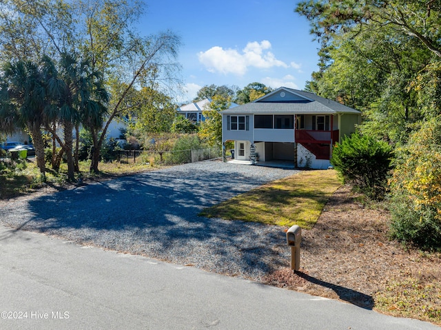 view of front of home with fence and gravel driveway