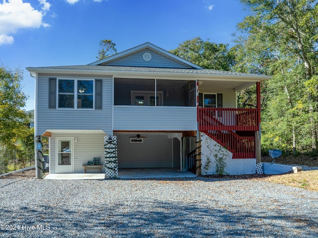 view of front of house featuring a carport, roof with shingles, and driveway