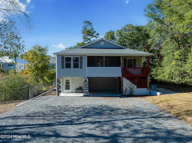 coastal inspired home with fence and gravel driveway