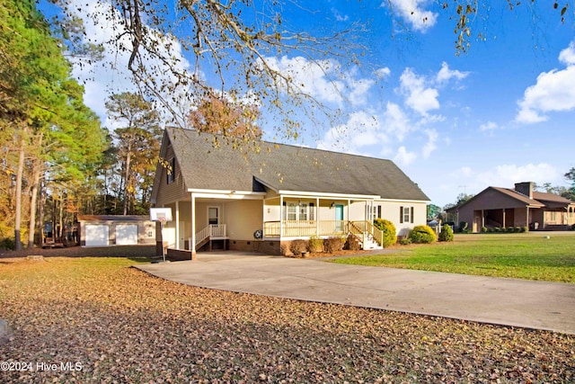 rear view of house with an outdoor structure, covered porch, a yard, and a garage