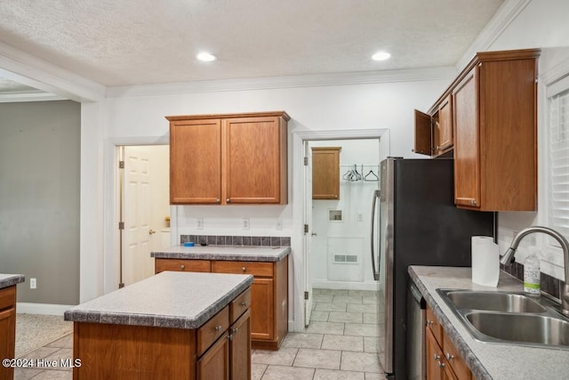 kitchen with a center island, stainless steel appliances, crown molding, and sink