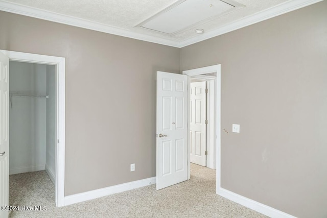 unfurnished bedroom with crown molding, light colored carpet, a textured ceiling, and a closet