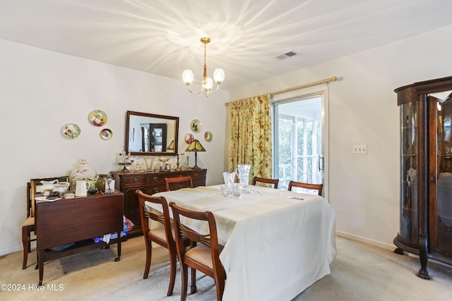 dining area featuring light carpet and a chandelier