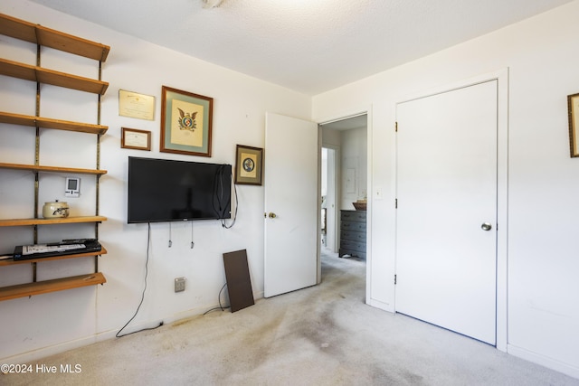 unfurnished bedroom featuring a textured ceiling and light carpet