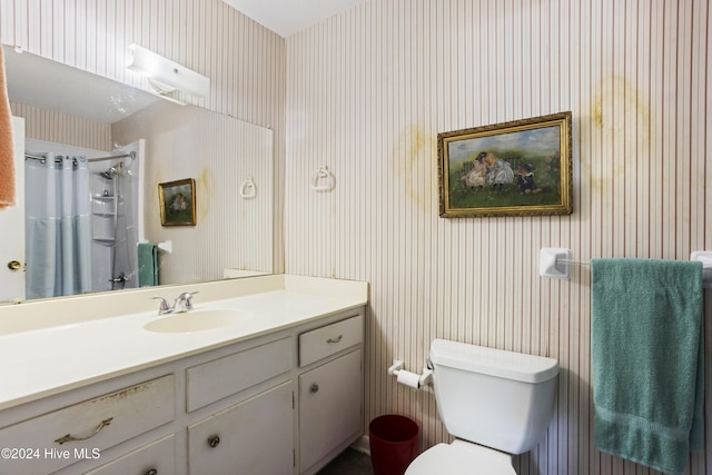 bathroom featuring a shower with shower curtain, vanity, and toilet