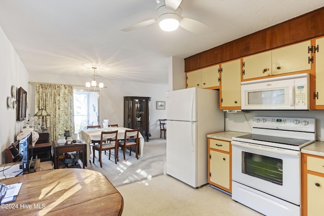 kitchen featuring ceiling fan with notable chandelier, white appliances, light colored carpet, and hanging light fixtures