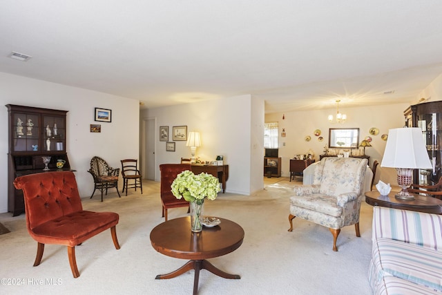 carpeted living room featuring a chandelier