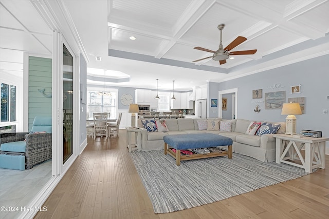 living room with ceiling fan, coffered ceiling, light hardwood / wood-style flooring, beamed ceiling, and ornamental molding