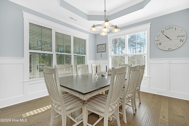 dining space featuring a chandelier, dark hardwood / wood-style flooring, a tray ceiling, and crown molding