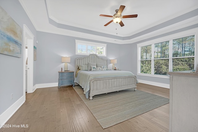 bedroom with multiple windows, ceiling fan, crown molding, and light hardwood / wood-style floors