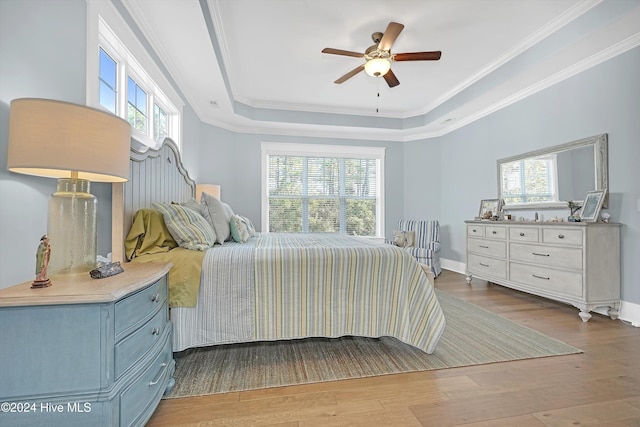 bedroom with hardwood / wood-style flooring, crown molding, and multiple windows