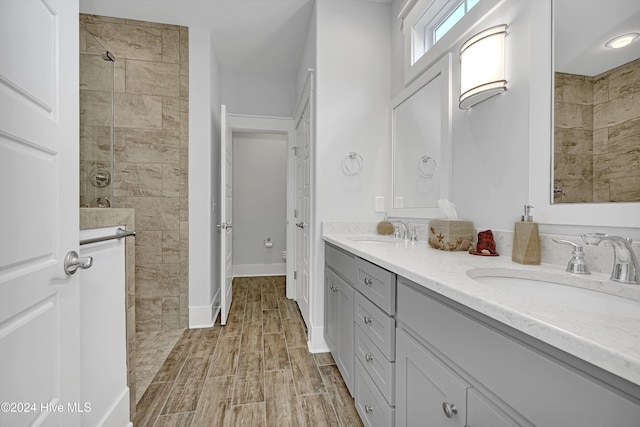 bathroom featuring a tile shower and vanity