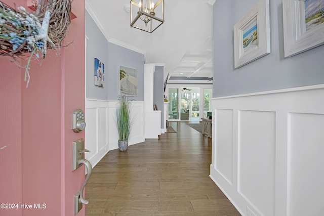 foyer entrance featuring coffered ceiling, beamed ceiling, hardwood / wood-style flooring, ceiling fan with notable chandelier, and ornamental molding