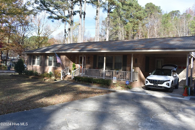 ranch-style home featuring a carport and a porch