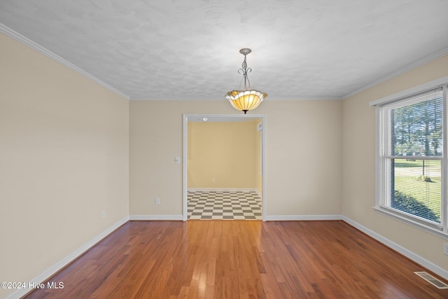 unfurnished room featuring hardwood / wood-style floors, crown molding, and a textured ceiling