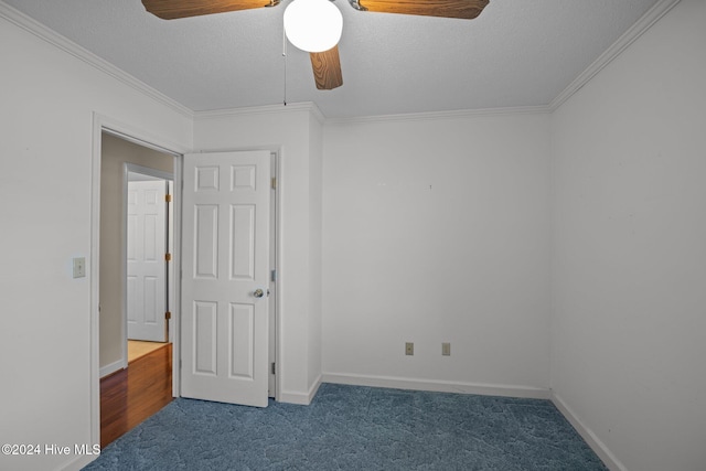 spare room featuring crown molding, ceiling fan, a textured ceiling, and dark colored carpet