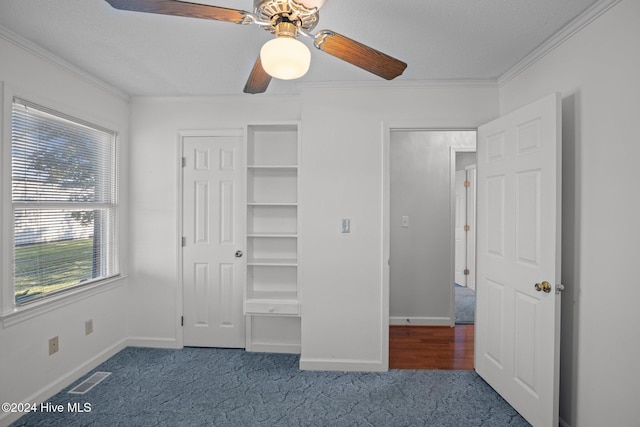 unfurnished bedroom featuring carpet flooring, ceiling fan, crown molding, and a textured ceiling