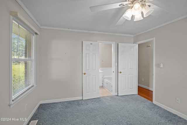 unfurnished bedroom featuring connected bathroom, ceiling fan, crown molding, light colored carpet, and a textured ceiling