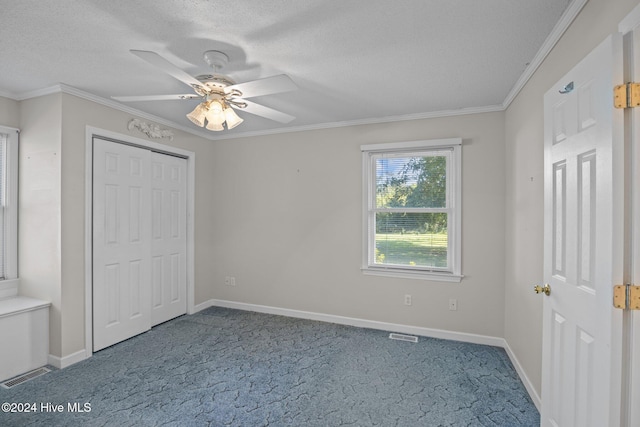 unfurnished bedroom featuring carpet, a textured ceiling, ceiling fan, and ornamental molding