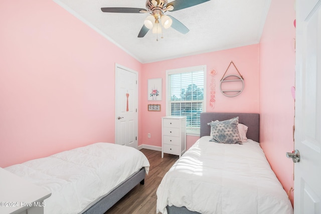 bedroom featuring dark hardwood / wood-style floors, ceiling fan, and crown molding