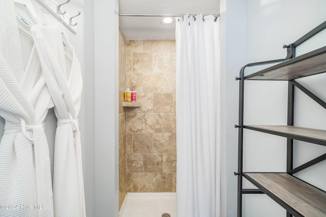 bathroom with a shower with curtain and a textured ceiling