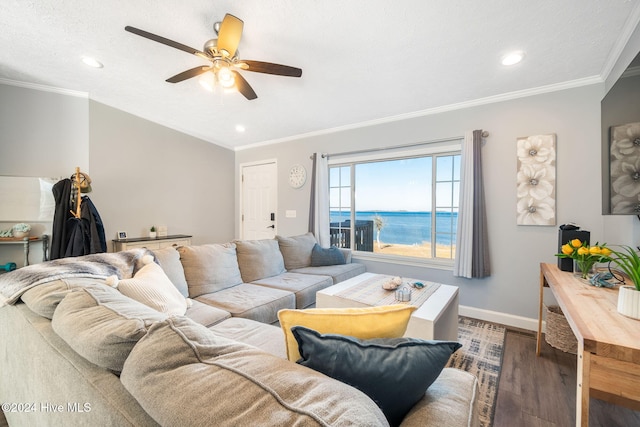 living room with ceiling fan, dark hardwood / wood-style flooring, a water view, and crown molding