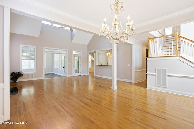 unfurnished living room with ornamental molding, a chandelier, vaulted ceiling, and light wood-type flooring