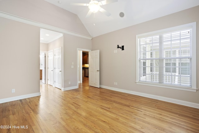 unfurnished bedroom featuring multiple windows, ceiling fan, vaulted ceiling, and light wood-type flooring