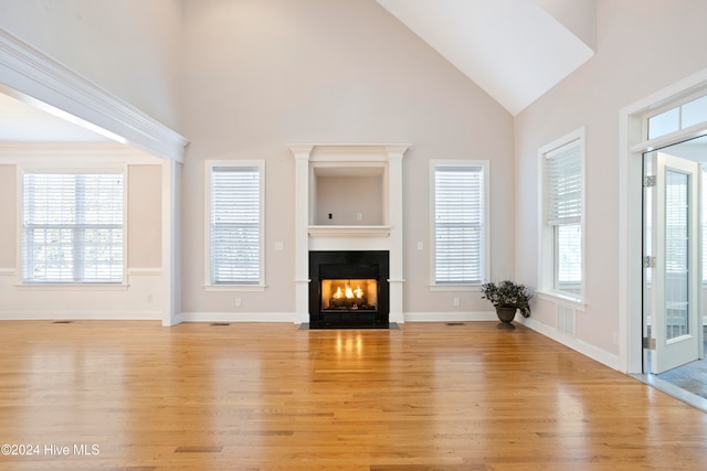 unfurnished living room featuring light wood-type flooring and high vaulted ceiling