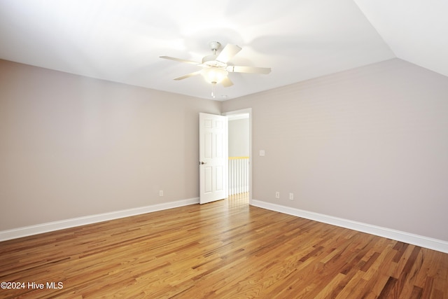 unfurnished room with ceiling fan, light hardwood / wood-style floors, and vaulted ceiling