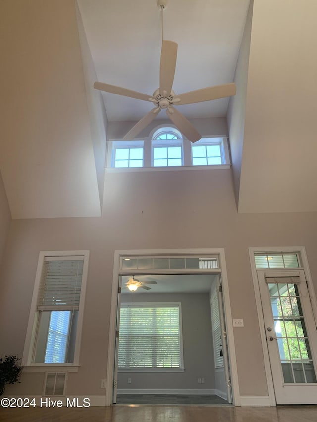 interior space with ceiling fan and a high ceiling