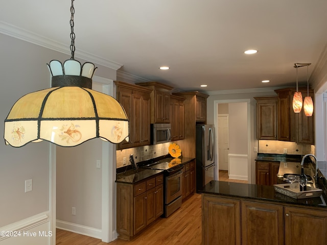 kitchen with decorative backsplash, decorative light fixtures, stainless steel appliances, and light hardwood / wood-style floors