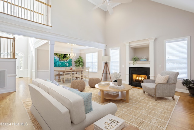 living room with hardwood / wood-style flooring, ceiling fan, and high vaulted ceiling