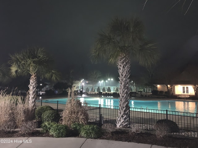 view of pool at twilight