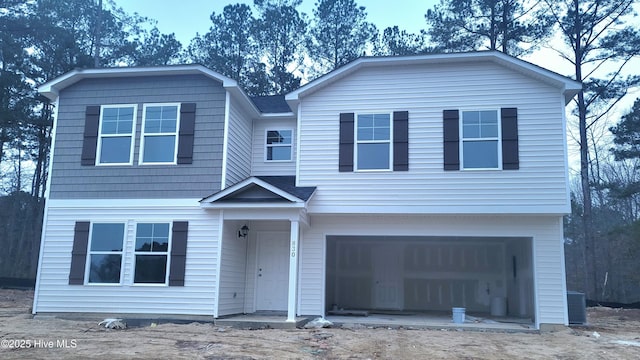 view of front of property with a garage and central AC unit