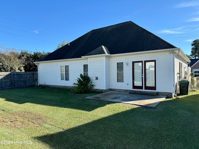 back of property with a lawn and a patio area