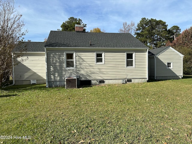 rear view of house with a yard and cooling unit