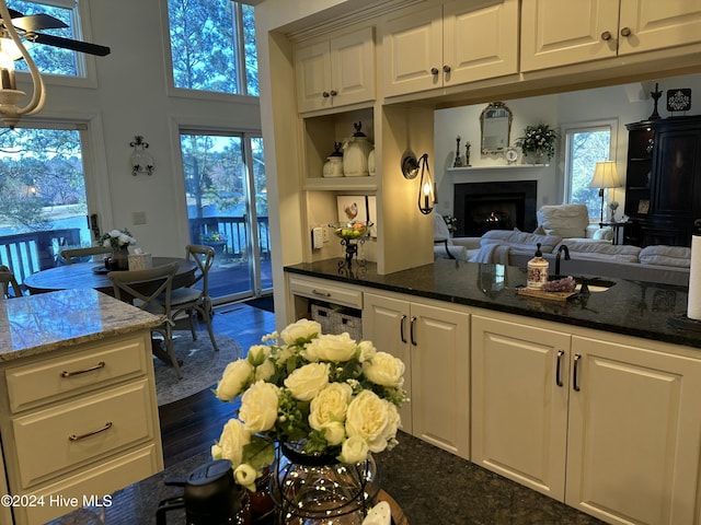 kitchen with white cabinets, dark hardwood / wood-style flooring, and dark stone counters